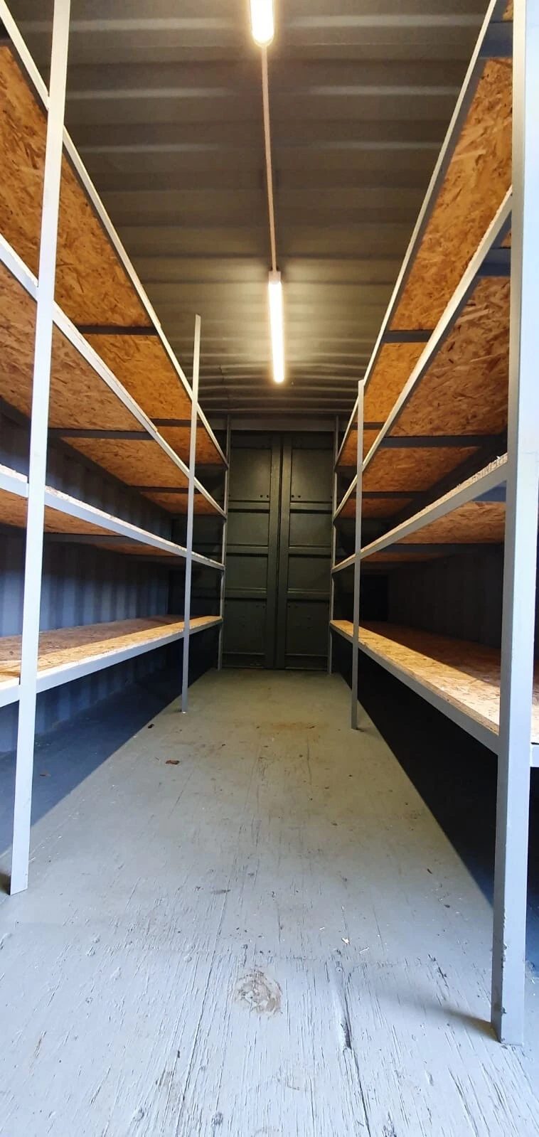 20ft High Cube Storage Container – Lighting and Shelving – container interior with wooden shelving and overhead strip lighting