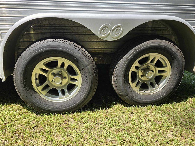 2000 C&C 2 Horse Gooseneck Trailer – Aluminum, Dressing Room – Close-up view of the double axles with aluminum wheels and black tires