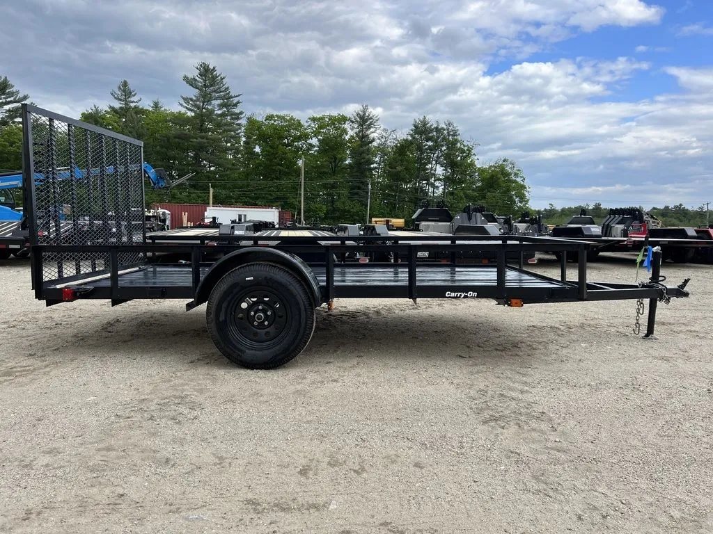2024 Carry-On 12 ft Utility Trailer – Rear Ramp Gate – A full side profile view of the black utility trailer on gravel