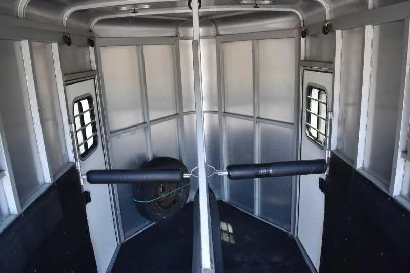 2004 Dalton 2 Horse Bumper Pull Trailer – Aluminum, Straight Load – Interior view of the horse trailer stalls showing the divider and padding
