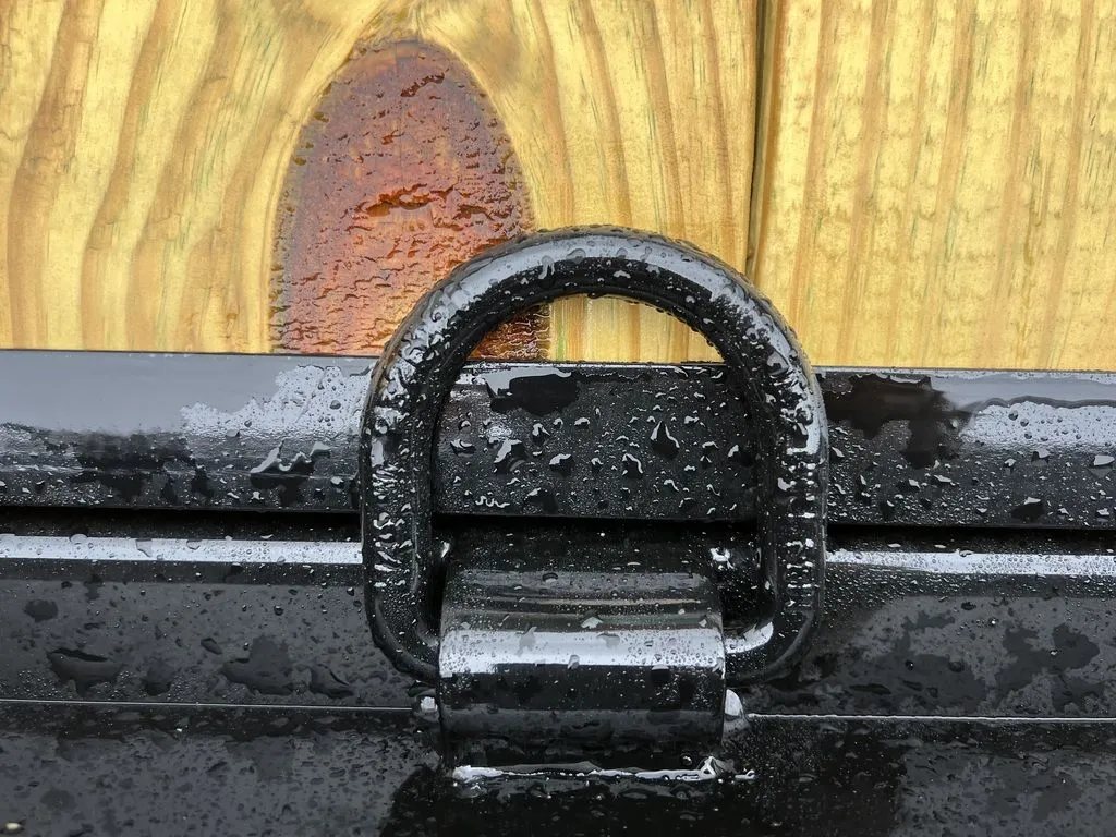 2024 Rice Trailers 16 ft Equipment Trailer – Toolbox – Close-up of a black metal D-ring tie-down point on the trailer frame