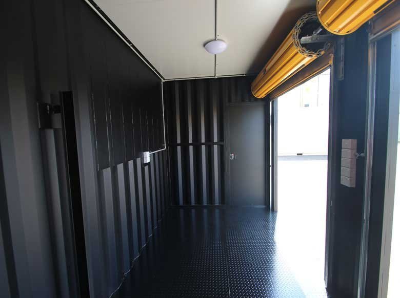 Trade Show Display Container – Lockable Steel Booth – Black interior of a container booth with electrical wiring and a ceiling light