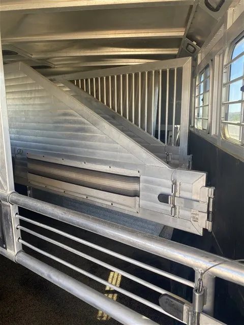 2000 Sooner 4 Horse Bumper Pull – Dressing Room, Awning – Close-up of the metal horse stall dividers inside the trailer