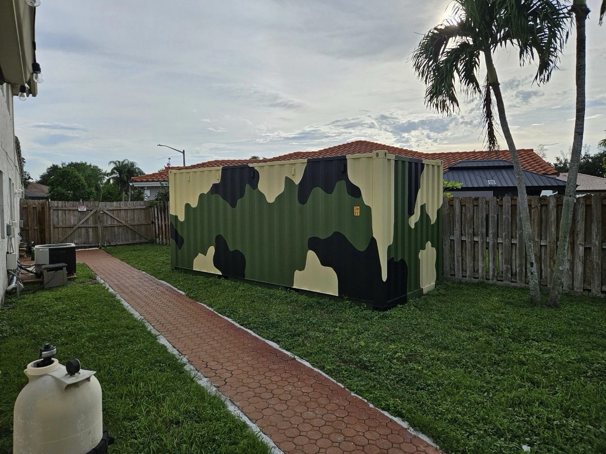20ft Wind & Watertight Storage Container – Camouflage Finish – three-quarter exterior view of camouflage container in residential yard