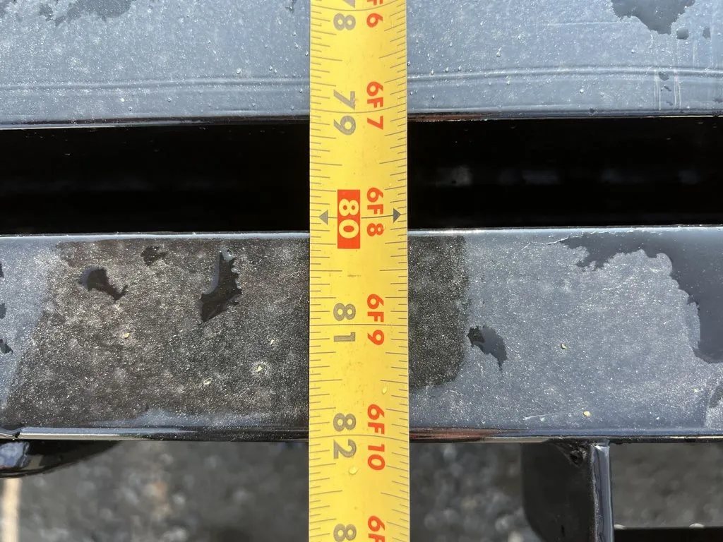 2024 Rice Trailers 20 ft Tilt Deck – Spare Mount – A yellow measuring tape showing dimensions against the black metal frame