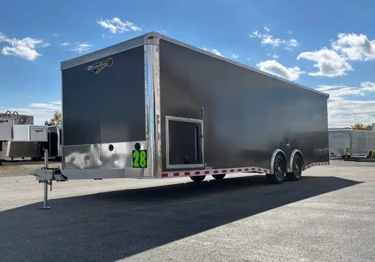2026 Millennium 28 ft Aluminum Car Hauler – Extreme – A side profile of the grey enclosed trailer showing the escape door and axles