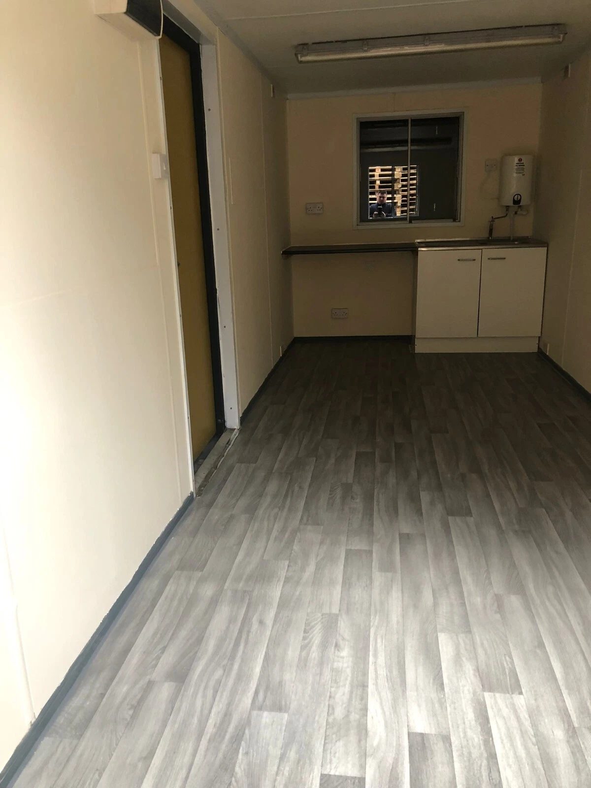 20ft Anti-Vandal Office Canteen – Insulated Steel Workspace – Empty canteen interior with sink, cabinets and wood-effect flooring
