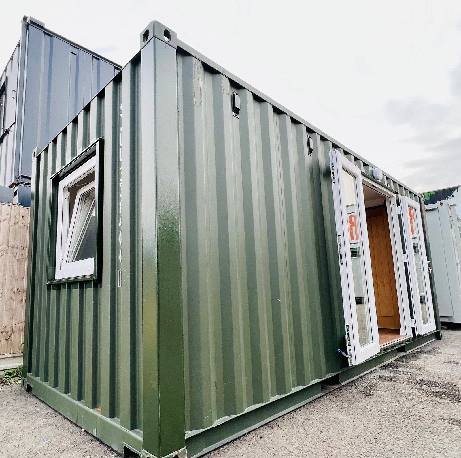 20ft Container Home – One Bed Box, 1 Bedroom – A refurbished 20ft container house featuring durable olive green paint and secure double-glazed glass entry doors