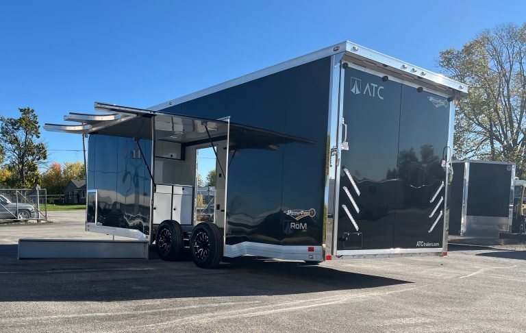 2026 ATC 24 ft ROM 550 Trailer – Black, Lithium – Rear three-quarter exterior view of a black trailer with a large open side door