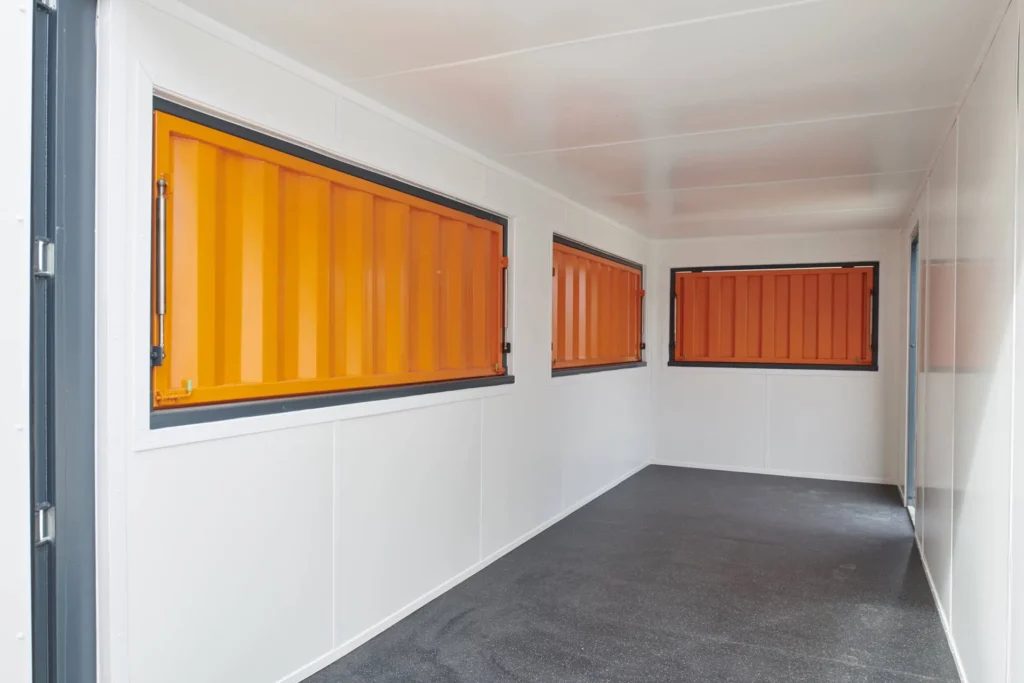 20ft Custom Container Café – Configurable Food Service Layout – empty white interior with orange serving shutters and gray floor