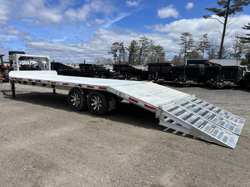 2024 Alum-Line 24 ft Gooseneck – Flip-Over Ramps – A three-quarter rear exterior view of a silver gooseneck trailer with ramps lowered