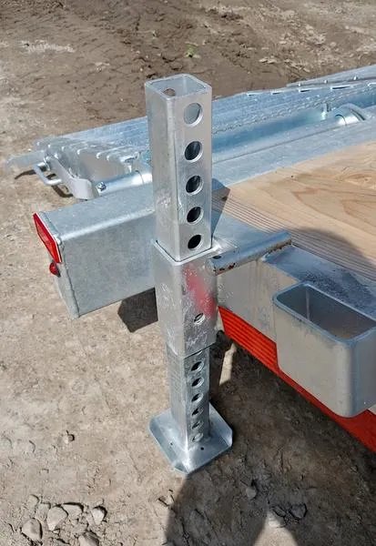 2024 N&N Trailers 20 ft Equipment Trailer – Full-Width Ramps – Close up of a galvanized adjustable rear stabilizer leg on the trailer frame