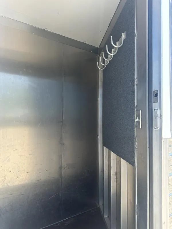 2020 Bloomer 4 Horse Stock Combo – Trainer Tack – Interior corner of the trailer with carpeted wall and hanging hooks