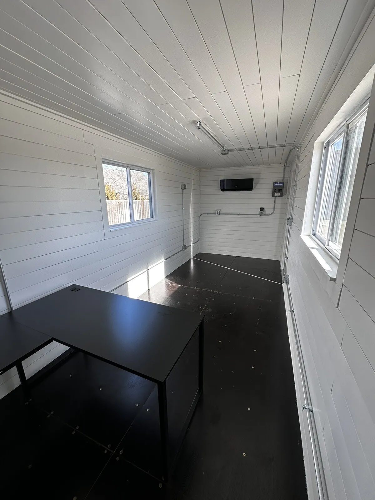 20ft Prefabricated Metal Office – Slate Gray Shiplap – Narrow office interior with white shiplap walls and black desk