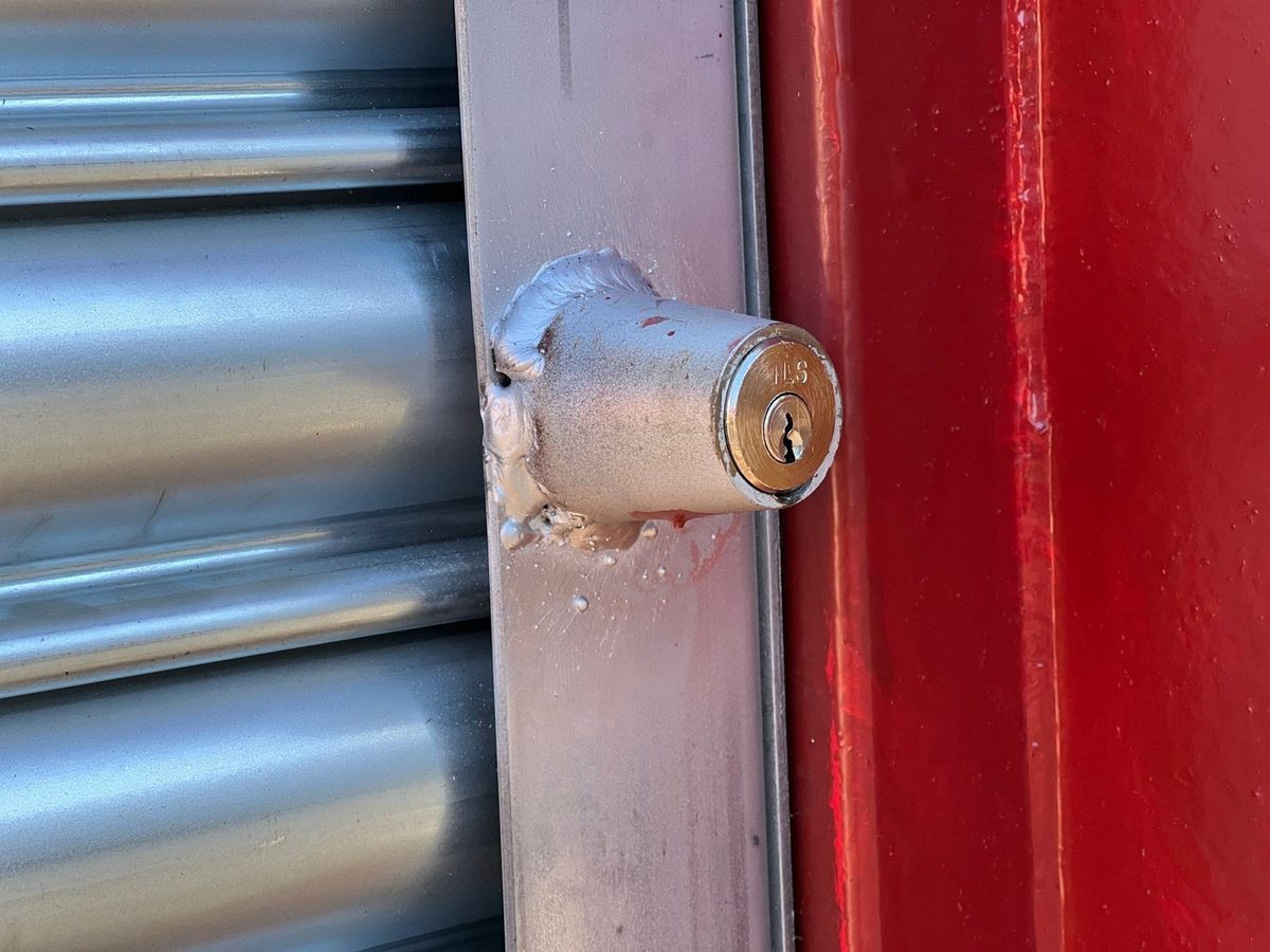 20ft Used Shipping Container – Roller Shutter Door – close-up of roller shutter lock on red container
