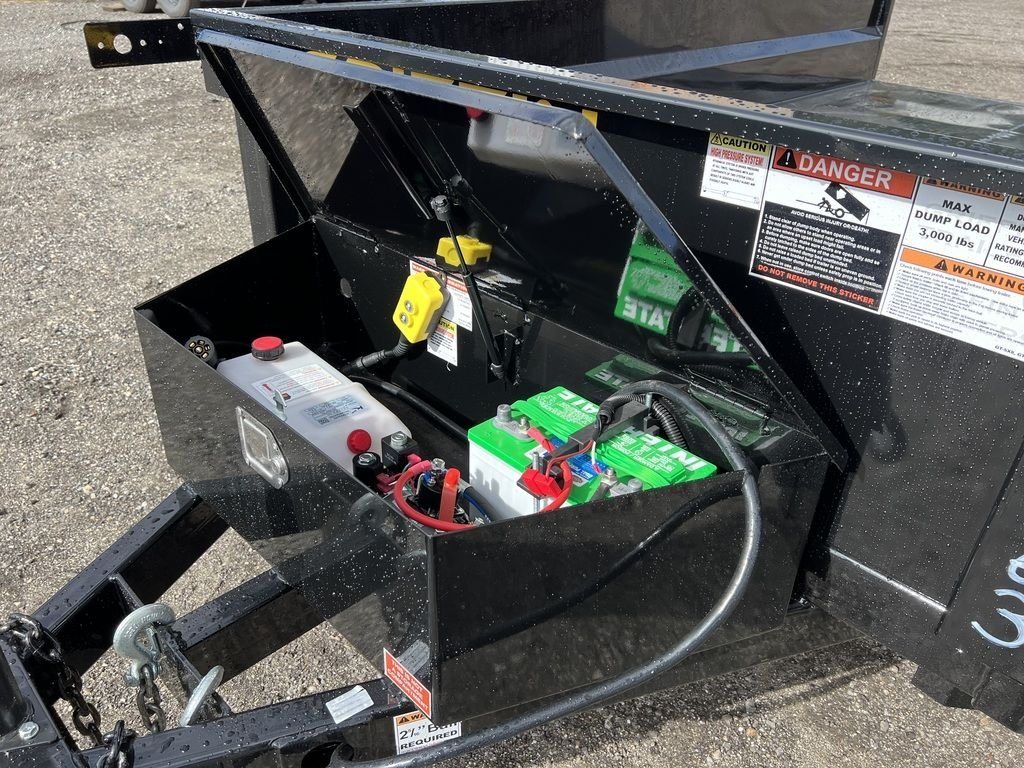 2024 Griffin Trailers 10 ft Dump – Barn Door Gate – Open black storage box on the front of the trailer containing the battery