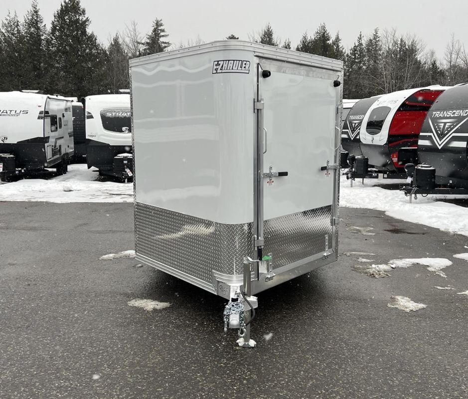 2024 E-Z Hauler 24 ft Trailer – Rear Canopy – Front view of the white V-nose trailer showing the front ramp and diamond plate