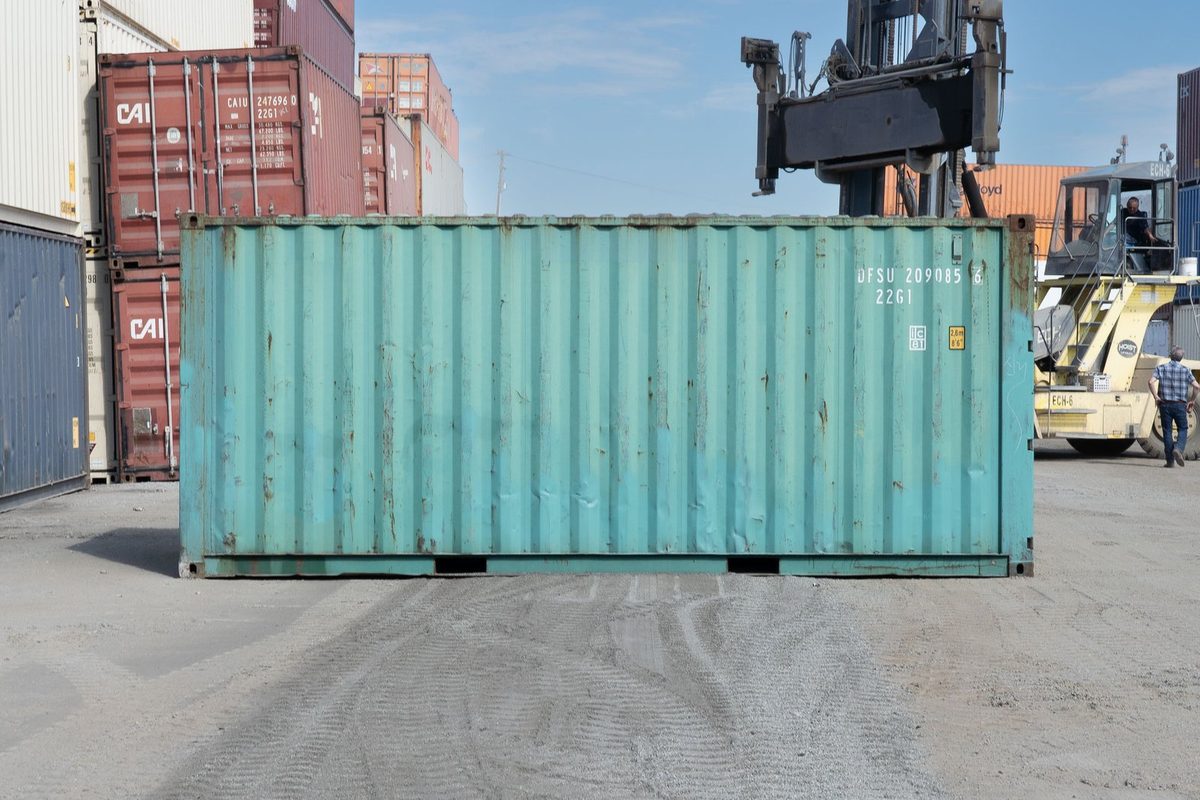 20ft Used Shipping Container – Storage-Class, Standard Height – side view of weathered container in busy storage yard
