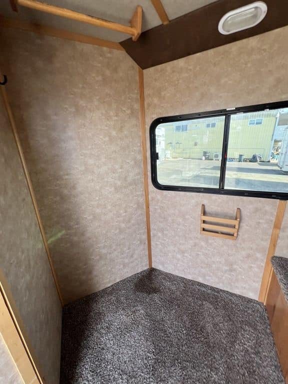2020 Trails West Sierra 4 Horse Gooseneck – Comfort Package – Empty carpeted living space with a side window and wood trim