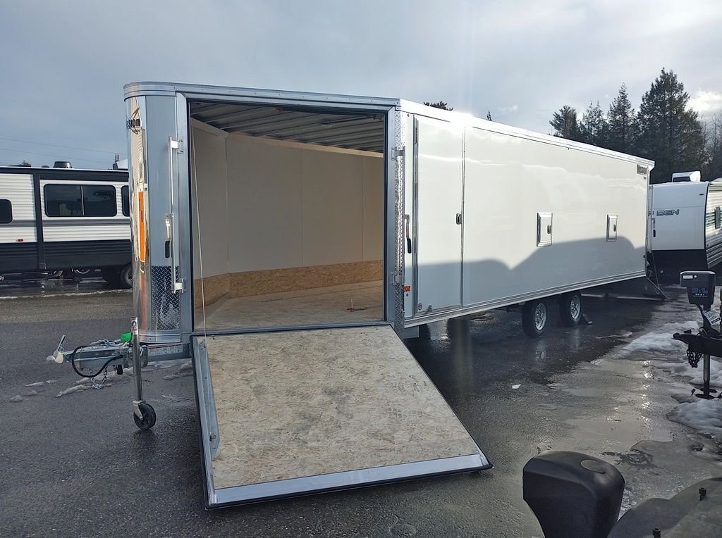 2024 Mission Trailers 24 ft Deckover – Galvanized Package – White enclosed trailer with the front ramp door fully extended to the ground