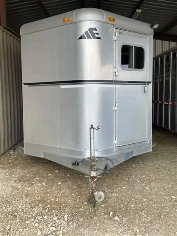 1999 Elite Custom 3 Horse Trailer – Rotating Saddle Rack – Front view of the gooseneck area and hitch under a shelter