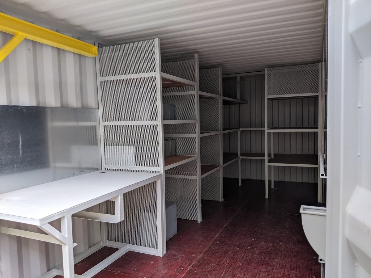 20ft Custom Workshop Container – Built-In Steel Shelving – workshop container interior with metal shelving and workbench