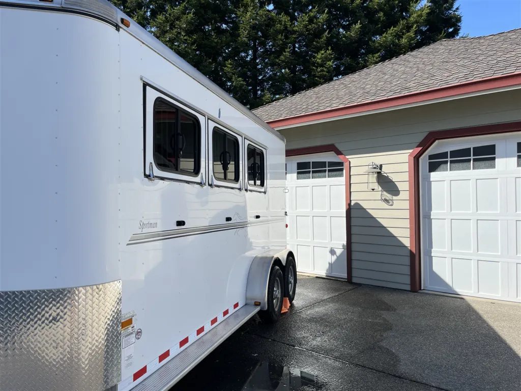 2013 Sundowner Sportsman 3 Horse Trailer – Extra-Large Tack Room – Side view of the trailer focusing on the windows and side decals