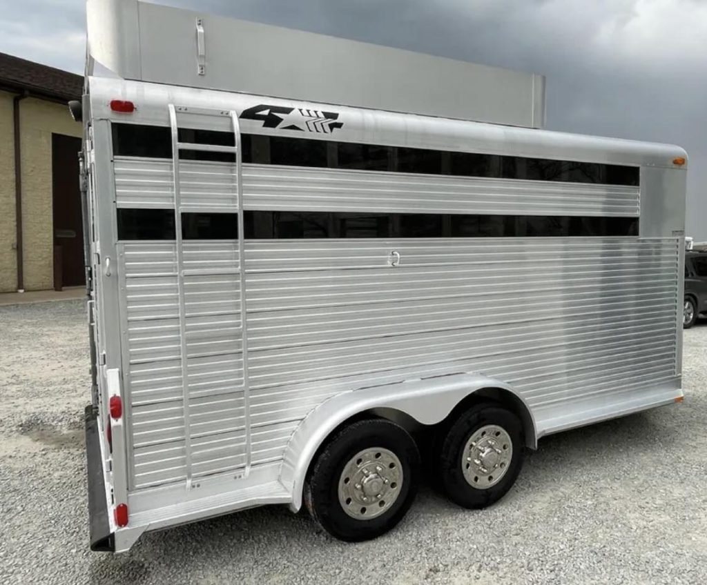 1999 4 Star 2 Horse Trailer – Reverse Slant / Stock Combo – Profile side view of the silver horse trailer showing wheels and a ladder