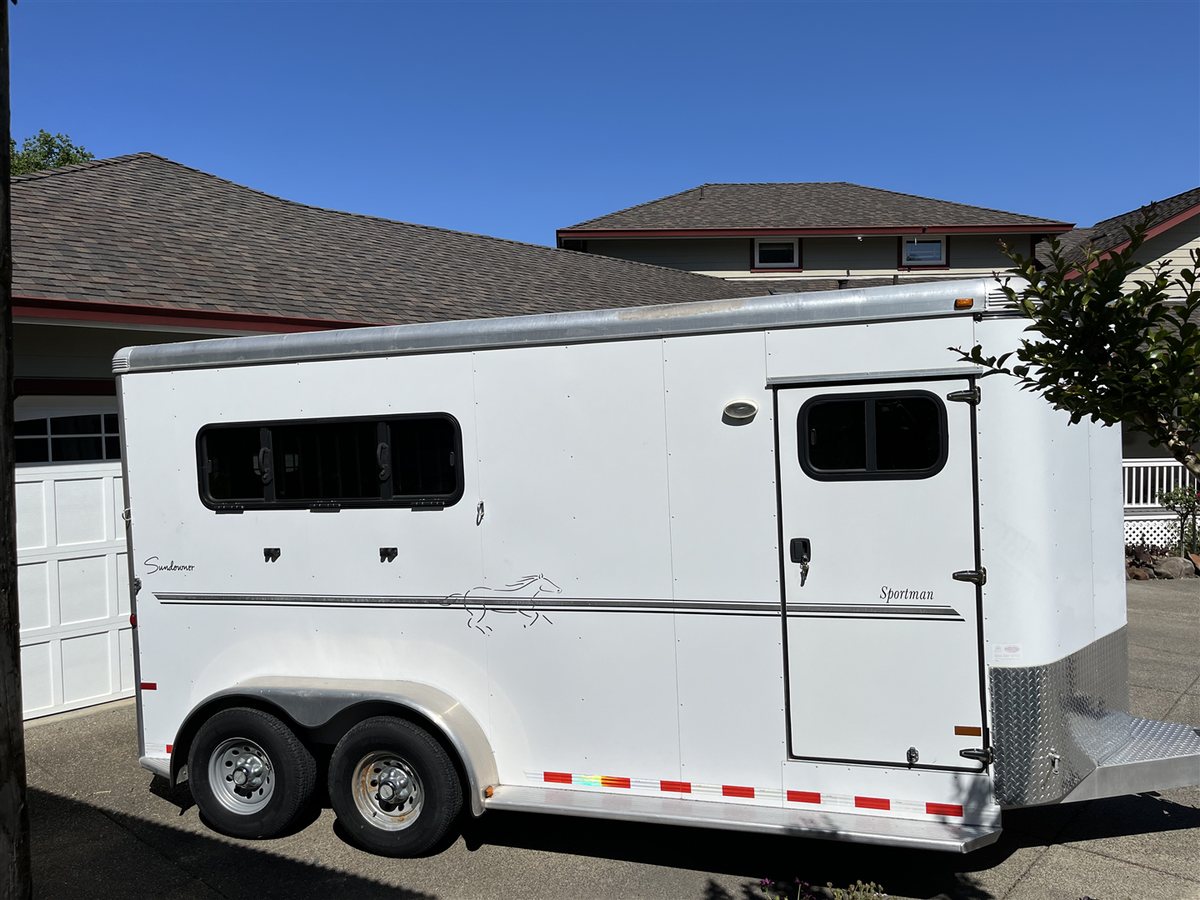 2013 Sundowner Sportsman 3 Horse Trailer – Extra-Large Tack Room – The street side of the white horse trailer with an access door and windows