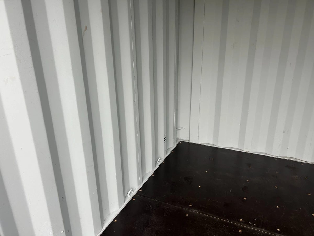 10ft New Shipping Container – Double Cargo Doors – Empty container interior corner with corrugated walls and dark floor