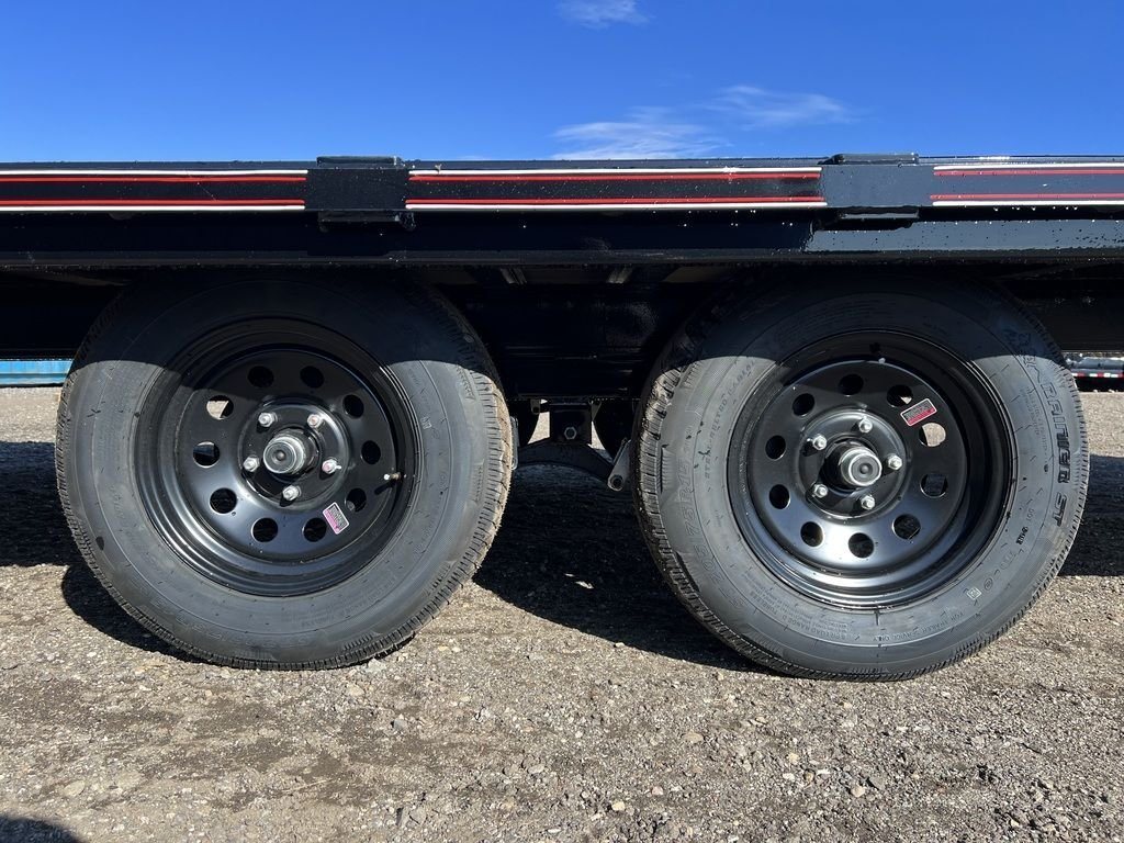 2024 Diamond C 20 ft Deckover – Slide-In Ramps – A close-up shot of the dual black axles and tires under the trailer