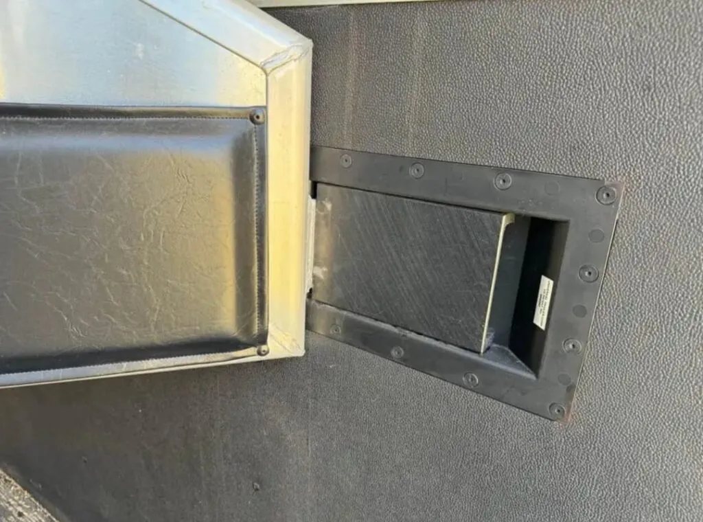 2008 Exiss Sport ES 30B 3 Horse Trailer – Slant Load – Close-up of a black padded stall divider latch inside the trailer