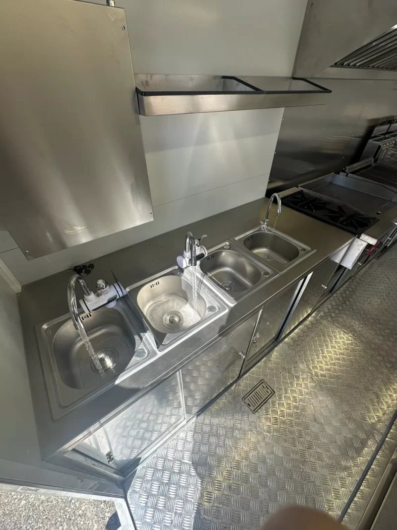 14 ft Food Trailer – Red Finish – Row of three stainless steel sinks with running water and faucets