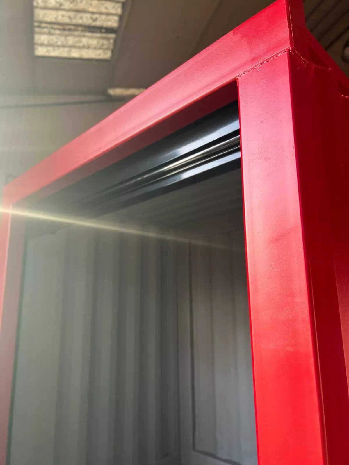 6ft Bespoke Storage Container – Motorized Roller Shutter – close-up of red container frame and raised roller shutter