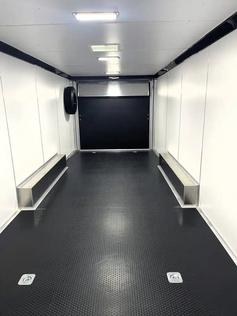 2026 Millennium 26 ft Car Hauler – White Aluminum – Clean interior view looking towards the rear ramp with black rubber flooring