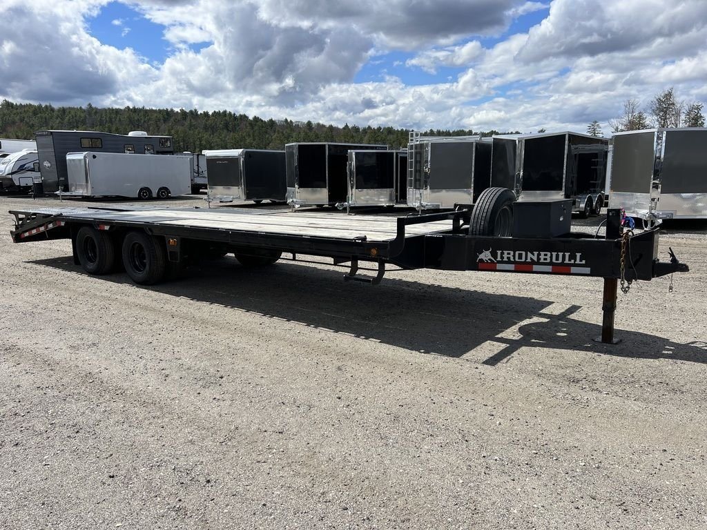 2022 Iron Bull Trailers Equipment Trailer – Rampage Ramps – Side profile of a long black deckover equipment trailer parked on a gravel lot