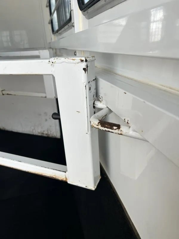 2000 Morgan Built 3 Horse Trailer – Bumper Pull – Close-up of a metal hinge and latch mechanism showing some rust
