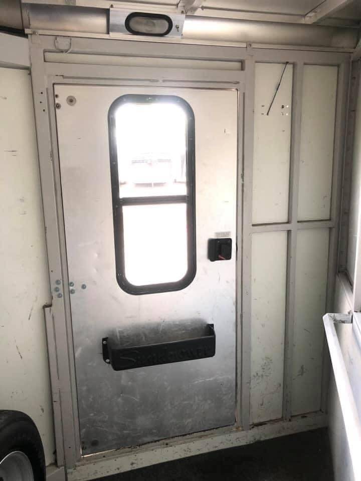 1998 Sundowner 3 Horse Slant Trailer – Dressing Room – Interior view of the dressing room door with a storage bin
