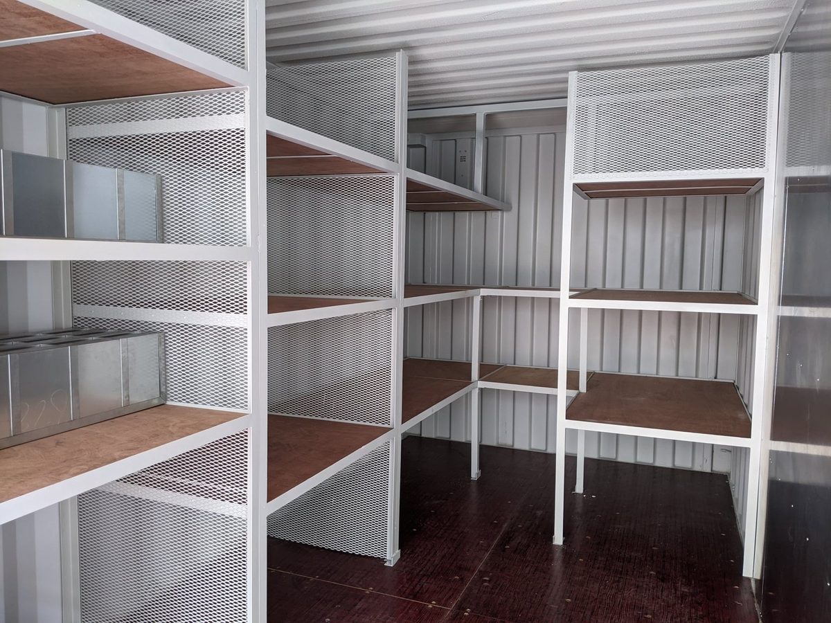 20ft Custom Workshop Container – Built-In Steel Shelving – Workshop container interior with metal shelving and wooden floor