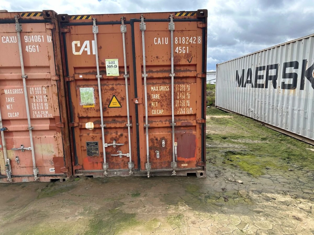 40ft Used Shipping Container – Secure Double Cargo Doors – closed cargo doors of rusty orange container in yard