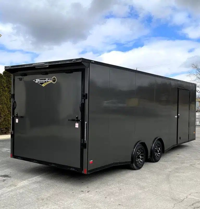 2025 Millennium 24 ft Car Hauler – Charcoal – Three-quarter rear view of the closed ramp door and black aluminum wheels