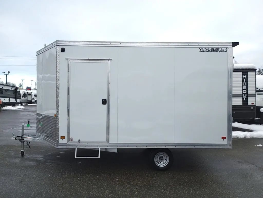 2024 Mission Trailers 12 ft Powersports – Side X Side – Full profile side view of the white enclosed trailer on a wet surface