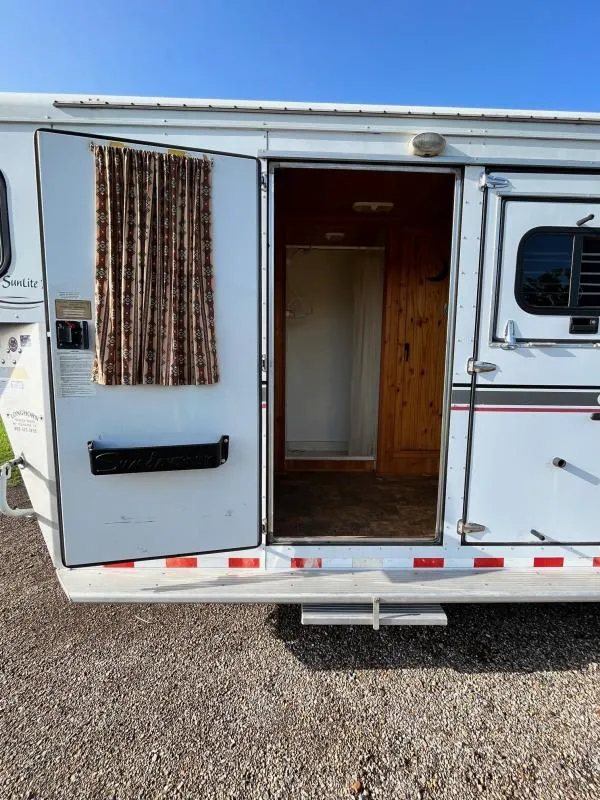 2004 Sundowner 3 Horse Trailer – Weekender Living Quarters – Open entry door revealing the wood-lined interior of the weekender living quarters