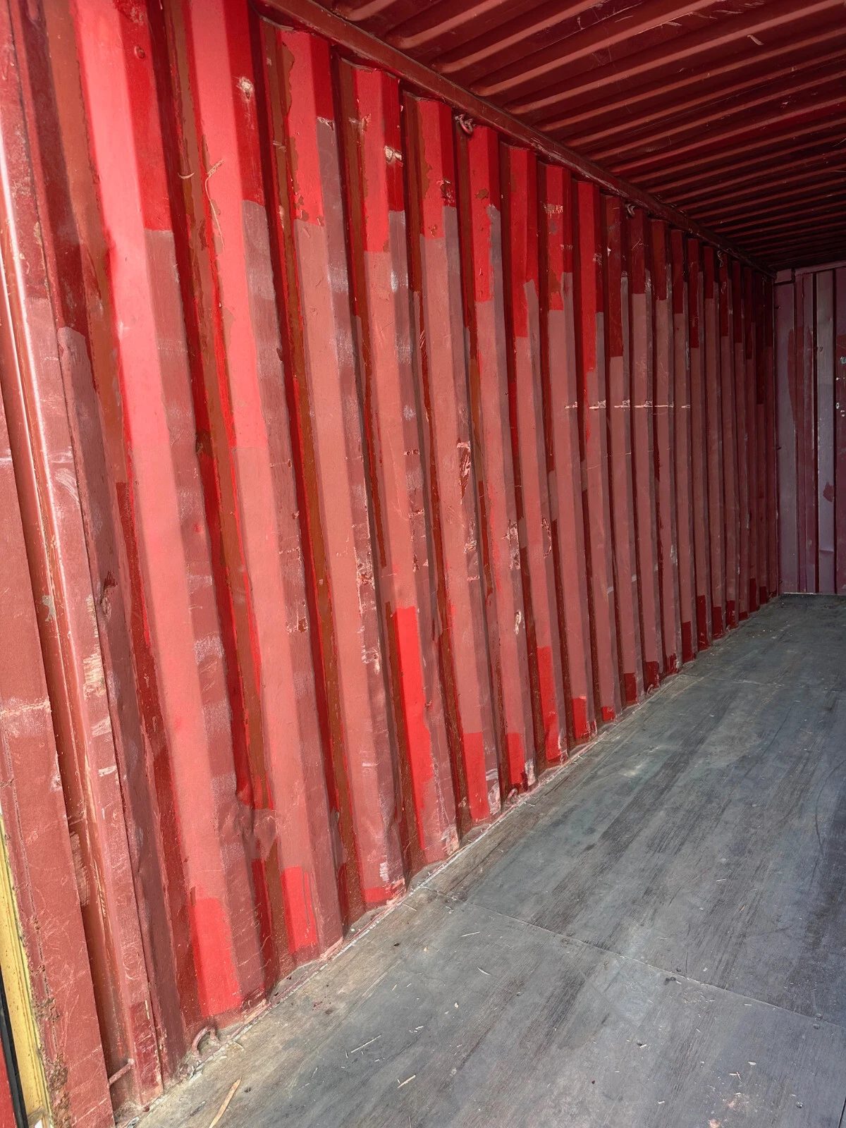 20ft Used Shipping Container – Yellow/Gold, Double Cargo Doors – empty container interior with red walls and worn wooden floor