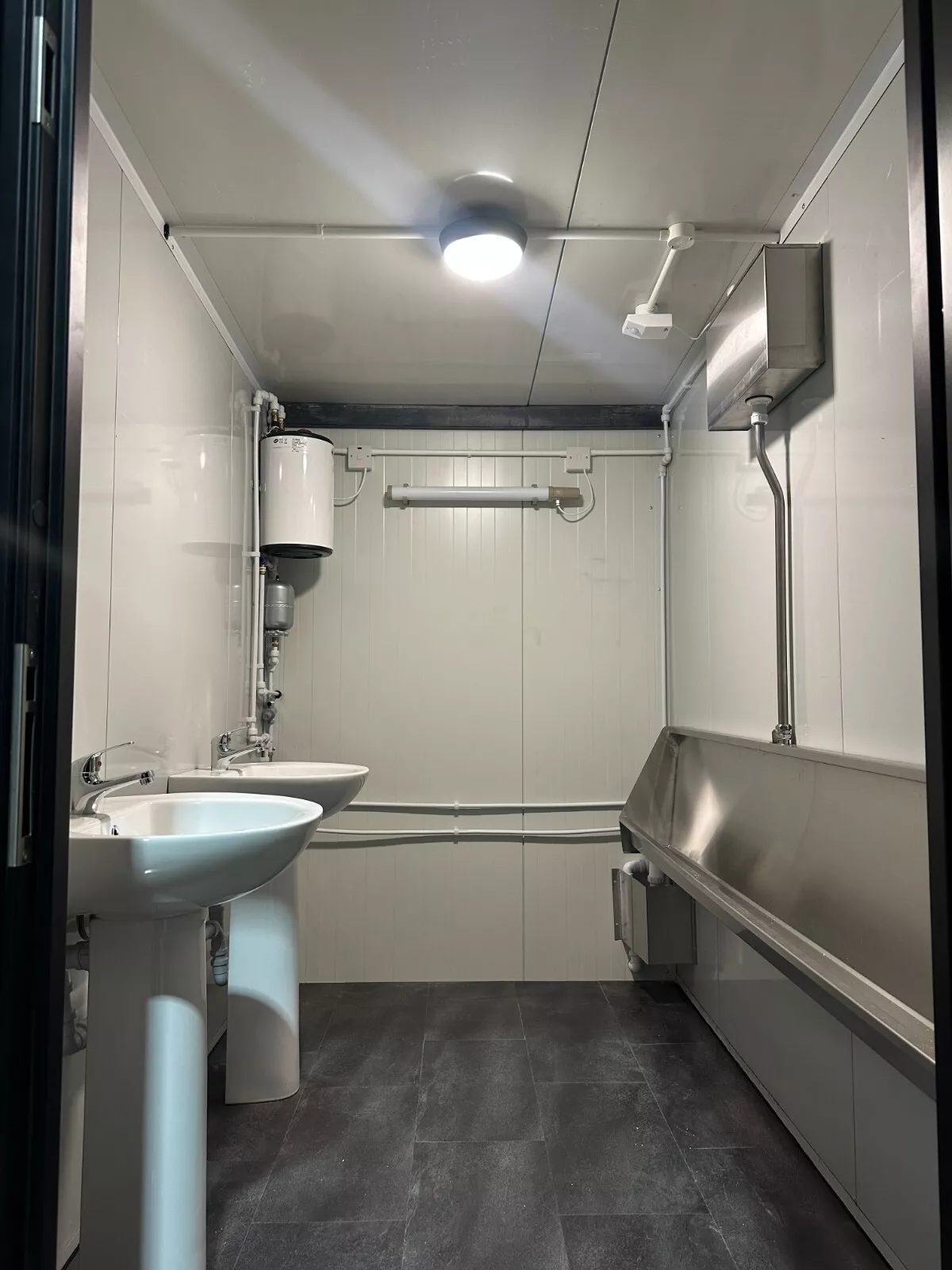 Custom Shipping Container Restroom – Three Private Compartments – Restroom interior with two pedestal sinks and stainless steel urinal