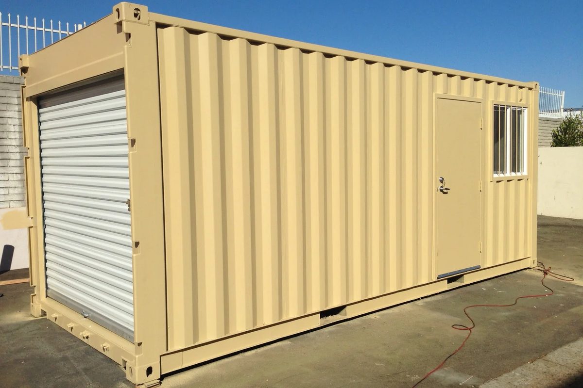 16ft Modified Storage Container – Front Roll-Up Door – Three-quarter exterior with closed roll-up door, side entrance and barred window