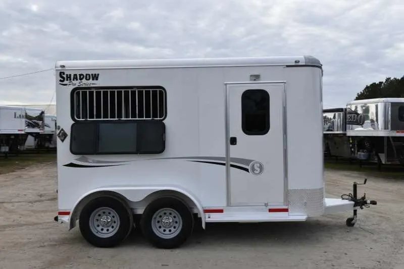 2016 Shadow 2HBP 2 Horse Bumper Pull Trailer – Aluminum – Right side of white horse trailer with window bars and entry door