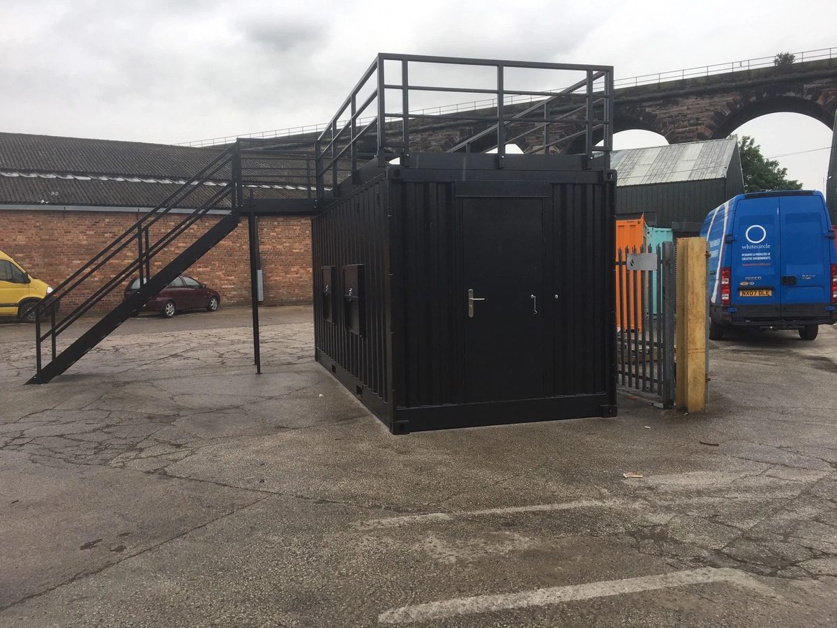 20ft Converted Shipping Container – Serving Hatches and Roof Deck – black converted container with rooftop railings and external staircase