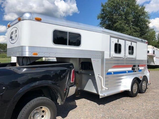 2004 4 Star 2 Horse Gooseneck Trailer – Slant Load, White – Front three-quarter view of a white and silver gooseneck horse trailer hitched to a truck
