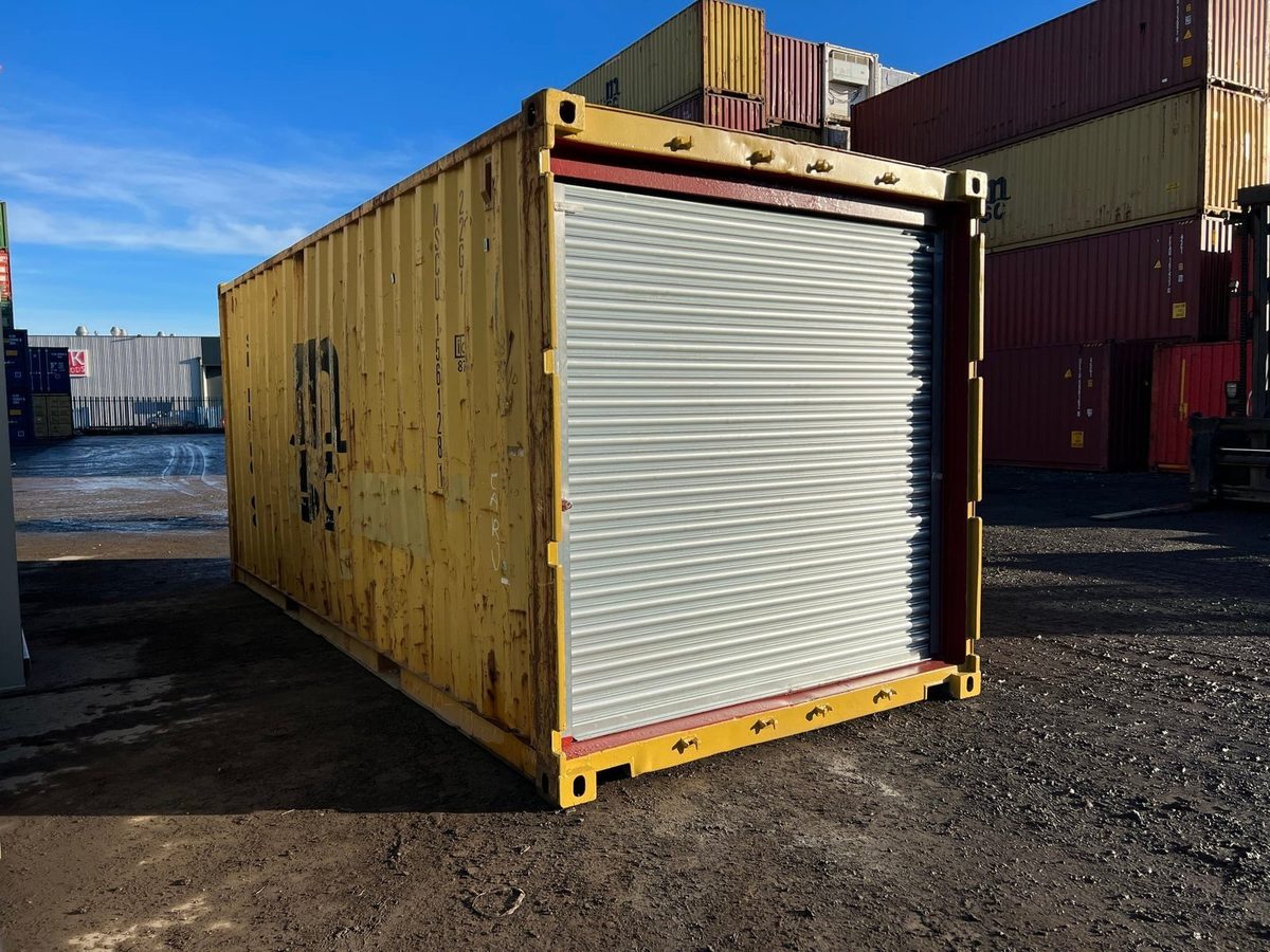 20ft Used Shipping Container – Roller Shutter Door – Three-quarter exterior view of yellow container with closed roller shutter